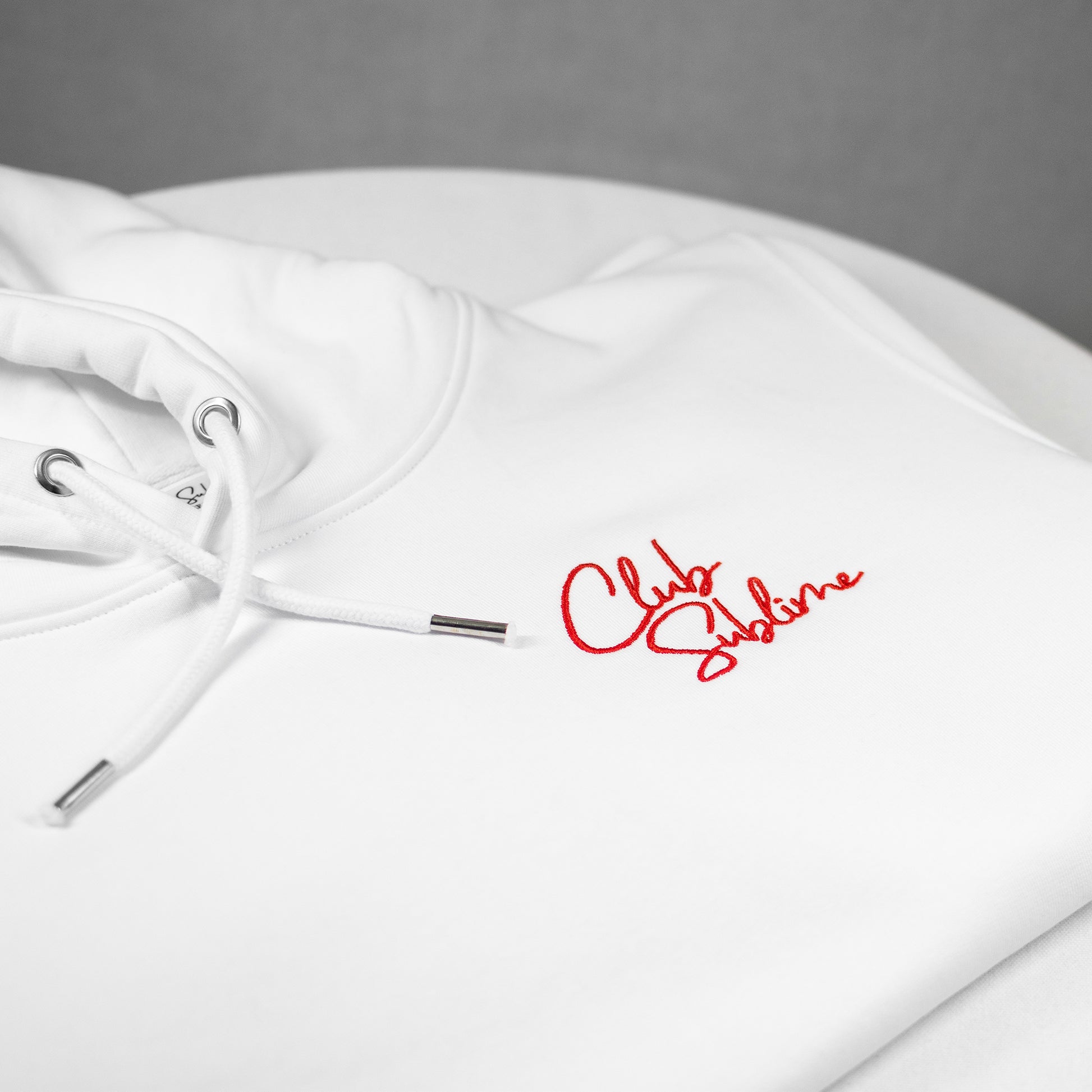 Notre hoodie "Le Sublime" de couleur Blanc Saturne : une pièce chaude et confortable avec le logo du Club sublimé par une fine broderie