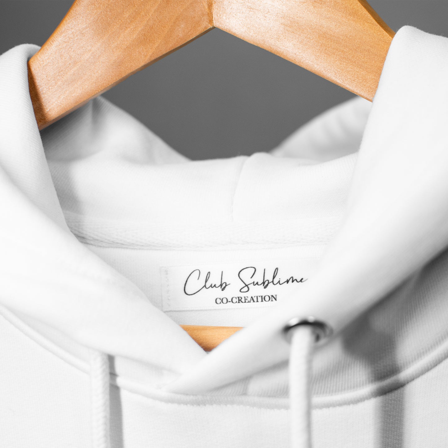 Notre hoodie "Le Sublime" de couleur Blanc Saturne : une pièce chaude et confortable avec le logo du Club sublimé par une fine broderie