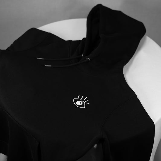 Le hoodie iconique du Club Sublime "Regard de Braise" de couleur Noir d'Encre transmet les valeurs du Club par son détail artistique brodé sur un pièce minimaliste et soignée. 