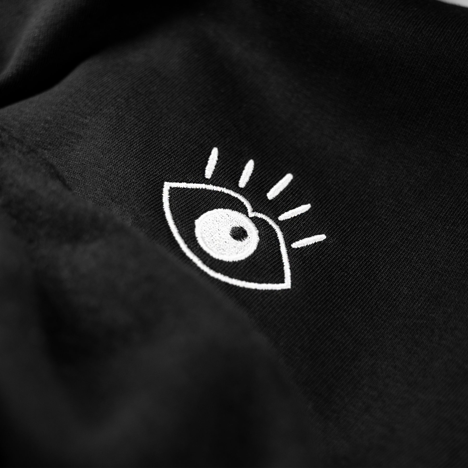 Le hoodie iconique du Club Sublime "Regard de Braise" de couleur Noir d'Encre transmet les valeurs du Club par son détail artistique brodé sur un pièce minimaliste et soignée. 